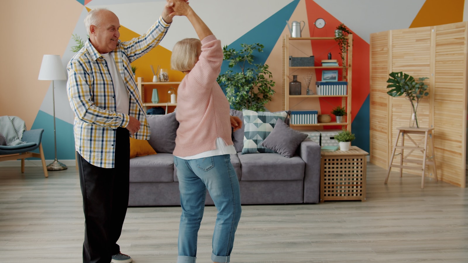 Elderly couple dancing joyfully at home
